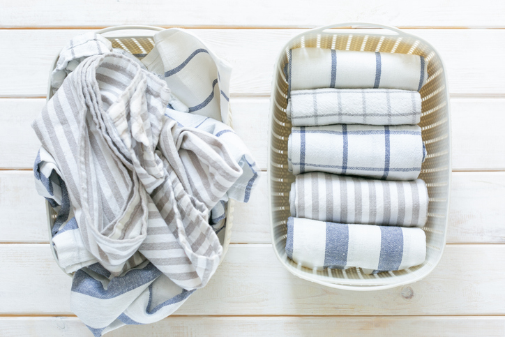 basket of messy towels next to basket of folded towels